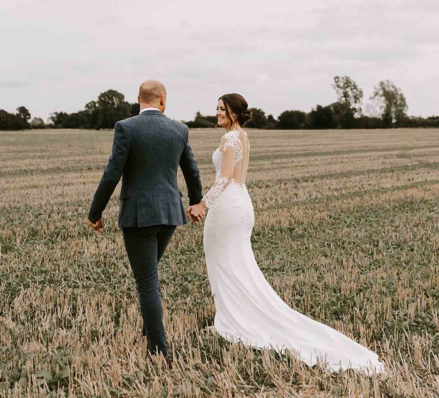 Сouple wearing a white gown and a black suit. Mobile image