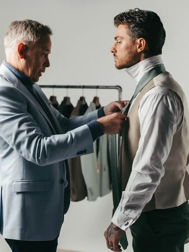 man tying up suit on groom